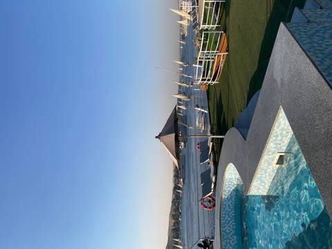 Deck with a swimming pool and river view on a sunny day.