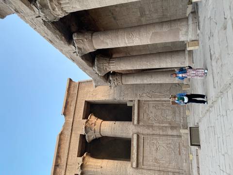 Ancient Egyptian temple with hieroglyphs and tourists.