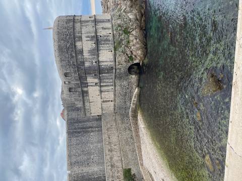       Robust stone walls of a historic fort along the coastline.
  