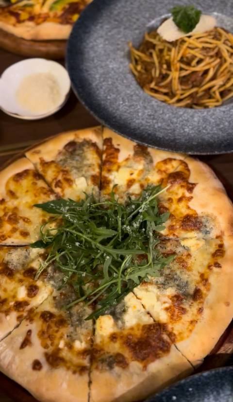 Pizza topped with arugula on a wooden board.