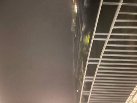       Blurry night view from a building balcony.
  