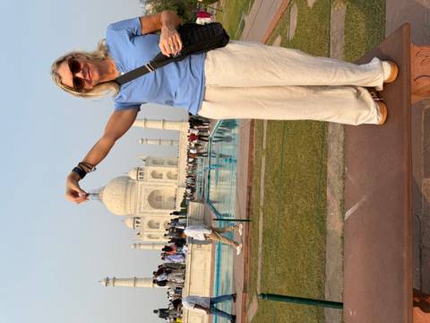 Woman posing as if holding the top of the Taj Mahal.