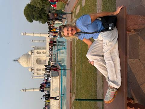 Woman sitting on a bench with the Taj Mahal in the background.