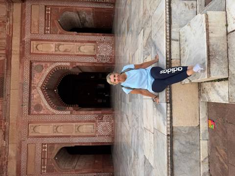       Woman sitting on stairs of a historical structure.
  