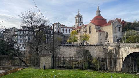 Historical church and surrounding buildings with a stone bridge.