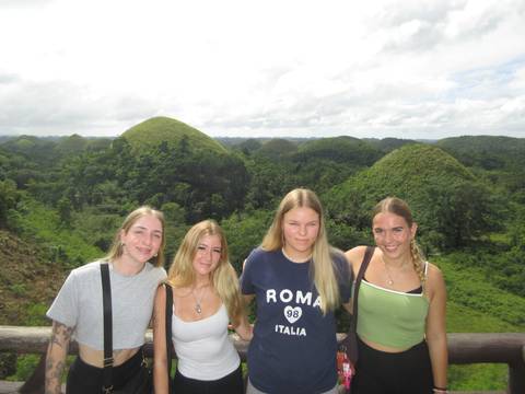 Four people with unique green hills in the background.