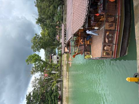 boats docked along a river with green surroundings.