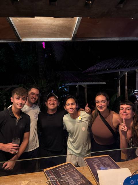 Group of people posing in a nighttime outdoor setting.