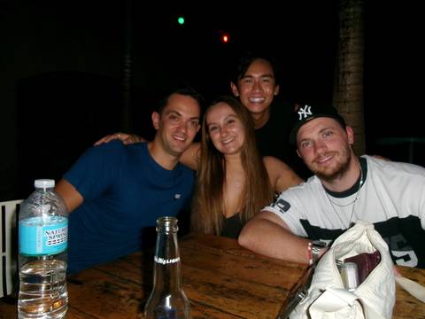 Four people gathered around a table, smiling at a nighttime setting