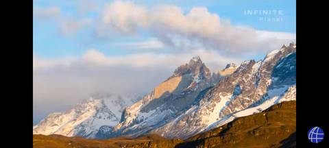       Dramatic sunset view of mountain peaks with clouds.
  