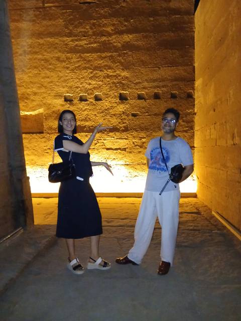       Two people posing inside an ancient Egyptian structure.
  