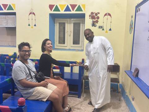       Group of people inside a room with colorful walls.
  