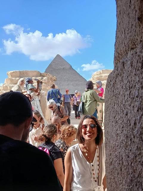 Crowd of tourists near the pyramids with blue skies.