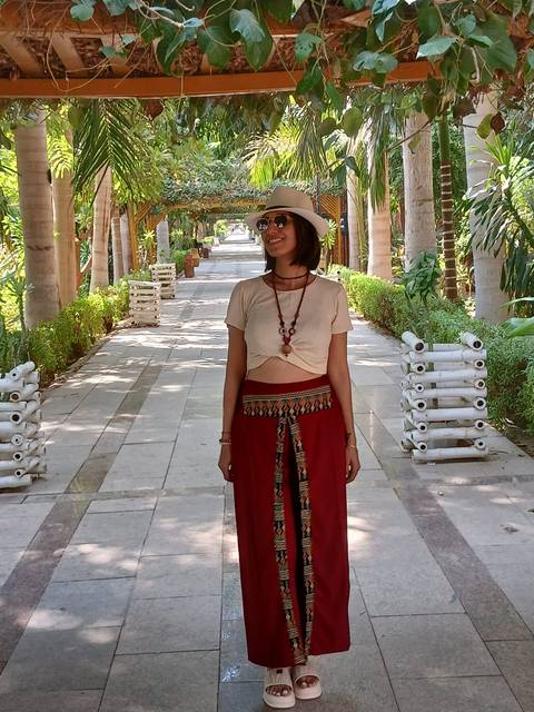       Woman walking down a path in a garden with floral decor.
  