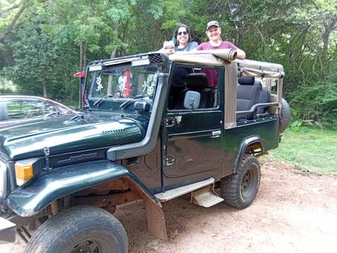 Off-road vehicle with two people standing behind it.