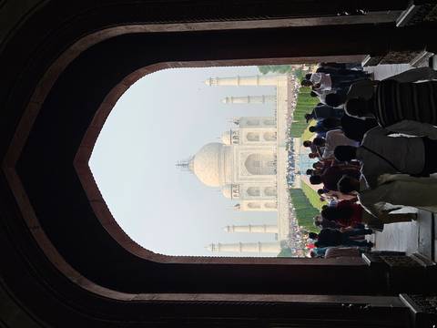       Taj Mahal viewed through large arched doorway.
  