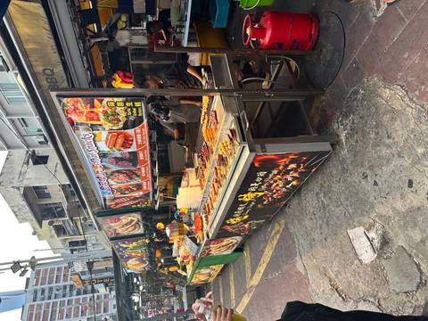 Street food vendor stall with a variety of skewered snacks on display.
