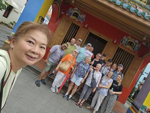       Group posing in front of a colorful building.
  