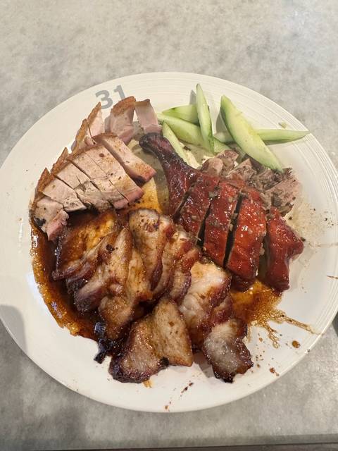       Plate of assorted roasted meats and cucumbers.
  