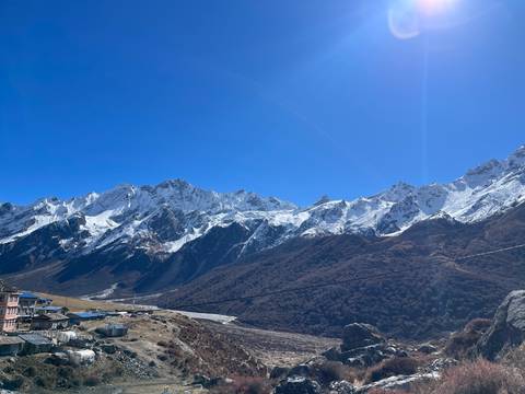      Panoramic view of snow-capped mountains under a clear blue sky.
  