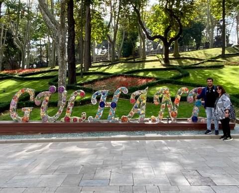 Two people by a flower sculpture spelling GÜLHANE.