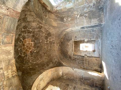 Stone passageway with circular ceiling detail.