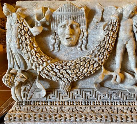 Stone carving with deity and grapes motif.