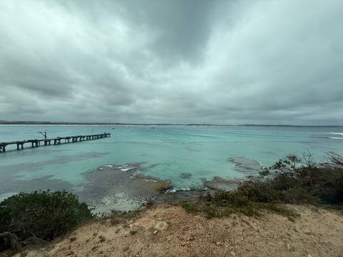       A serene view of a coastal bay with turquoise water.
  