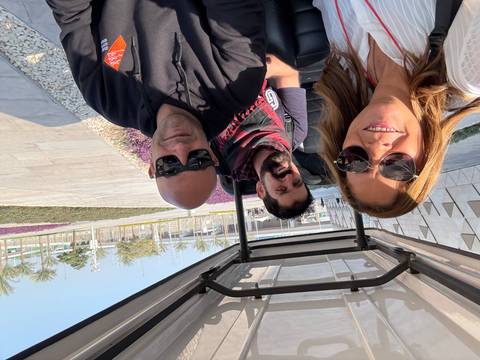       Group of people in a golf cart outdoors.
  