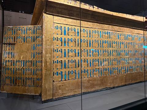       Close-up of ancient artifact with intricate blue and gold patterns.
  