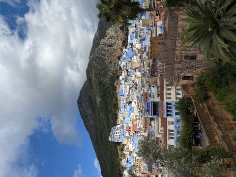       View of the blue city nestled in the mountains.
  