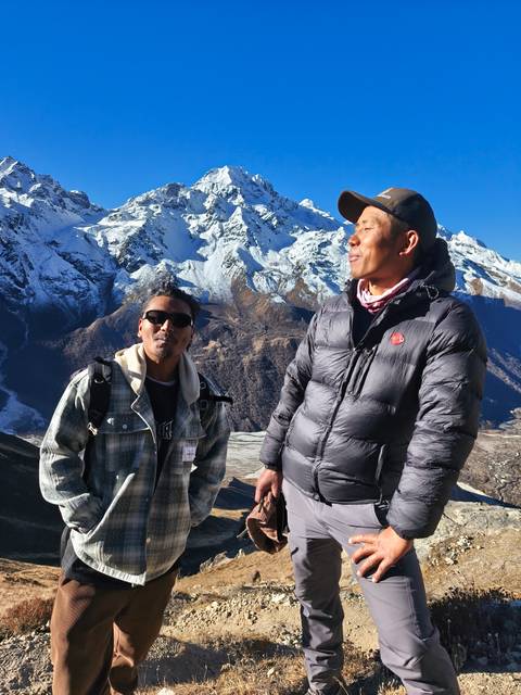 Two men enjoying a view of snow-capped mountains.
