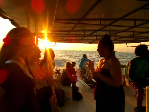       People on a boat ride during sunset.
  