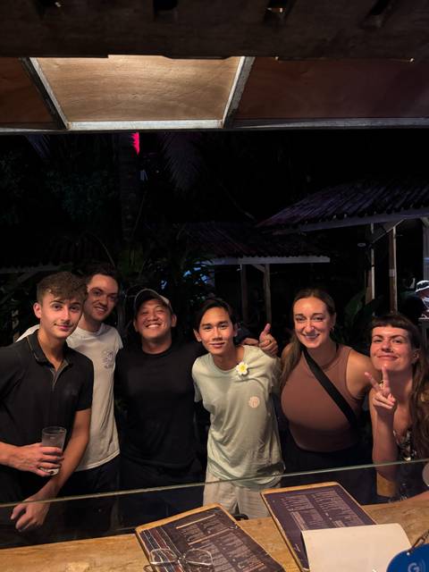 Group of people posing together in an outdoor setting at night.