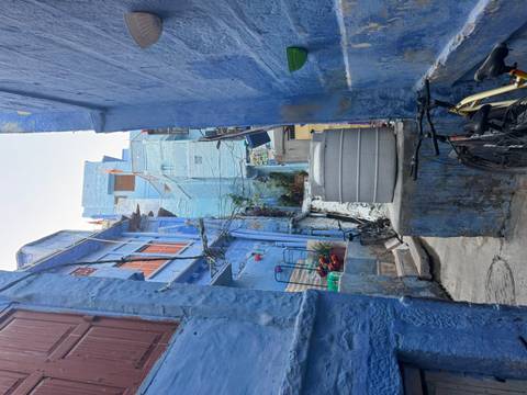 Narrow alleyway with blue-painted buildings.