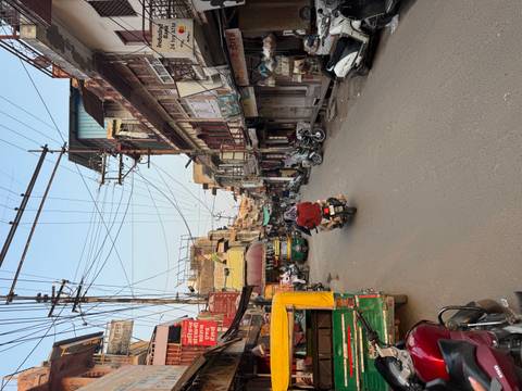 Bustling street scene with motorbikes, cars, and traditional buildings.