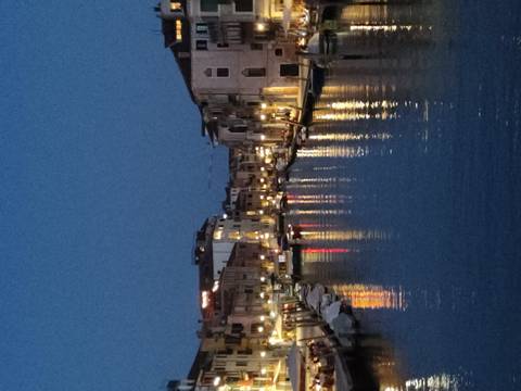       Night view of a canal with reflections of lights.
  