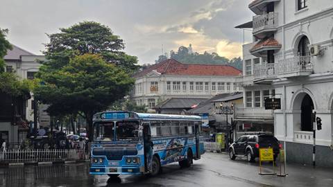       Colorful city street with local transport and distinctive architecture.
  