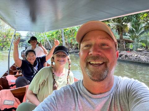 Group of people enjoying a boat ride on a canal.