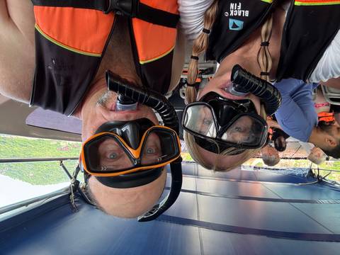 Couple wearing snorkeling gear on a boat.