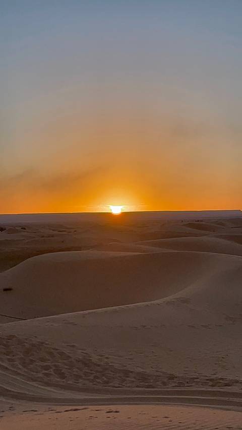       Sunset over sand dunes in the desert.
  