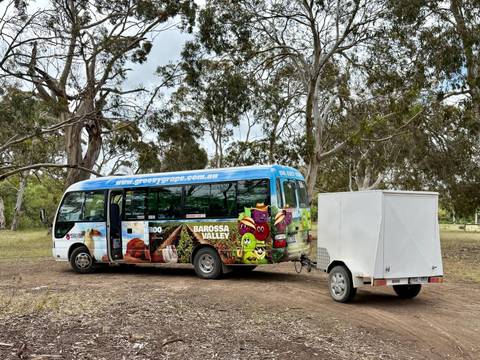       Colorful tour bus parked among trees in a rural area.
  