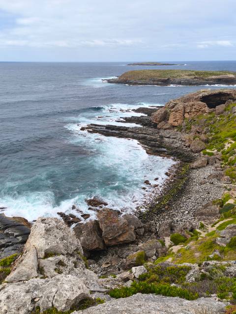       Rocky coastline with waves crashing against the shore.
  