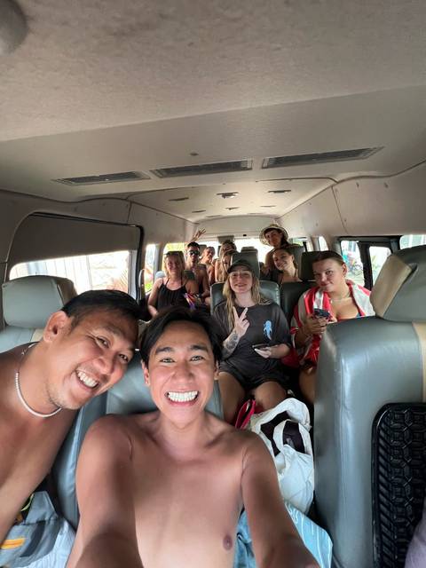       Group of people smiling inside a van.
  