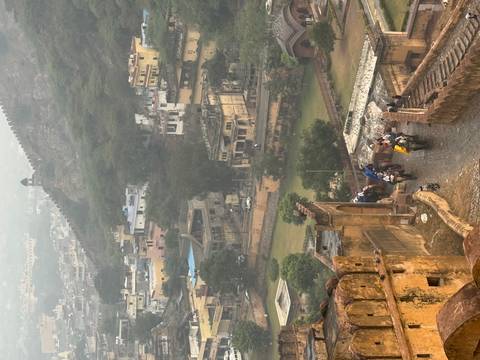 View of Amer Fort with people riding elephants in the foreground.