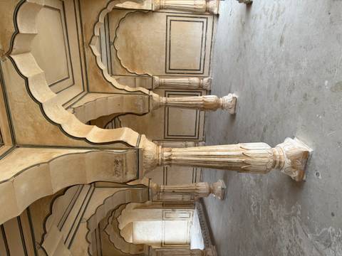 Historical columns with arches in a palace setting.