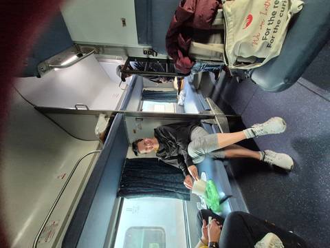 A person sitting in a train compartment.