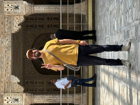 A person posing in front of an ornate building.