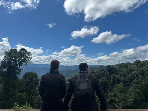       Two people standing on a cliff enjoying the view.
  