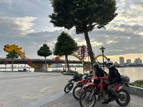       Motorcyclists beside the famous Dragon Bridge in Vietnam.
  